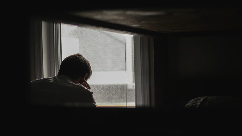 sad man in front of window