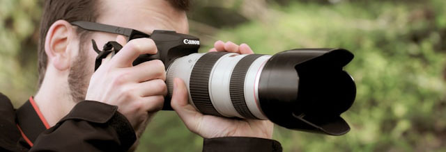 man in brown jacket holding black dslr